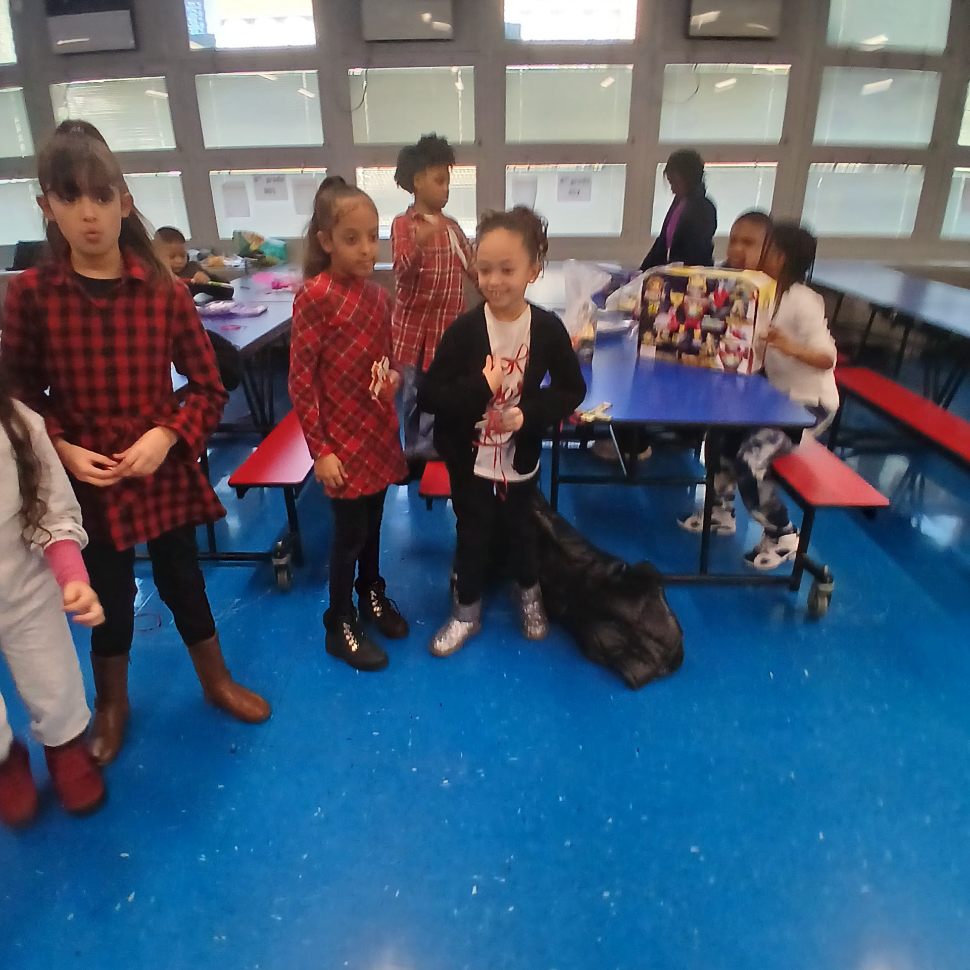 Children standing together in a room with gift tables behind them